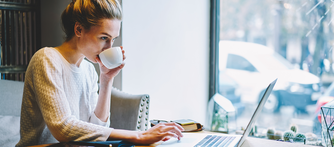 The Future of Work: 10 Benefits of Remote and Hybrid Working Woman sat at desk working on laptop in home environment to support remote and hybrid work article