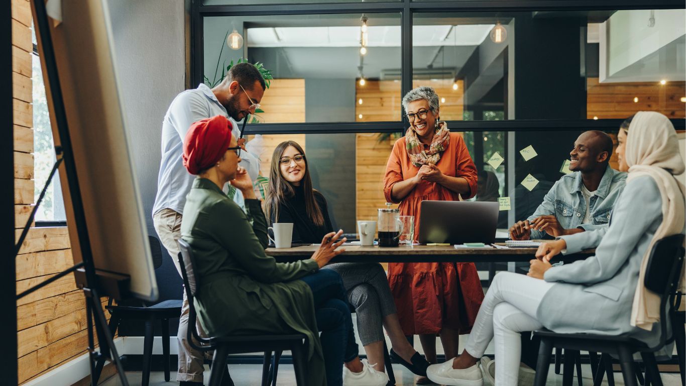 A diverse group of employees collaborating at a workplace meeting, reflecting diversity, equity and inclusion in the workplace.