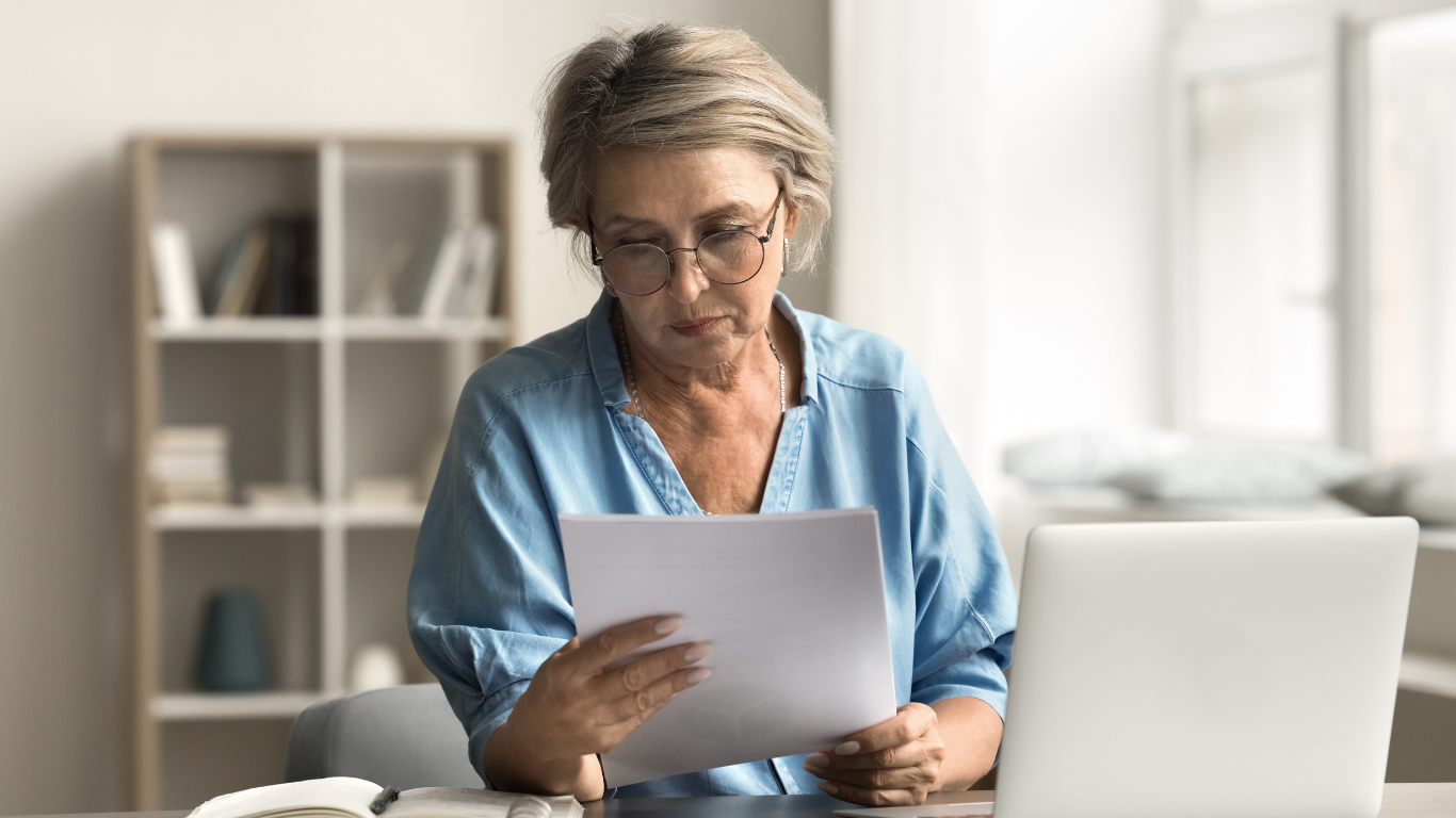 A professional reviewing documents at her desk, symbolizing the process of crafting a vision statement with clarity and purpose.