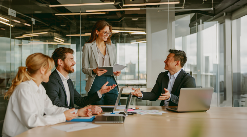 emotionally intelligent leadership in business setting with colleagues smiling at each other