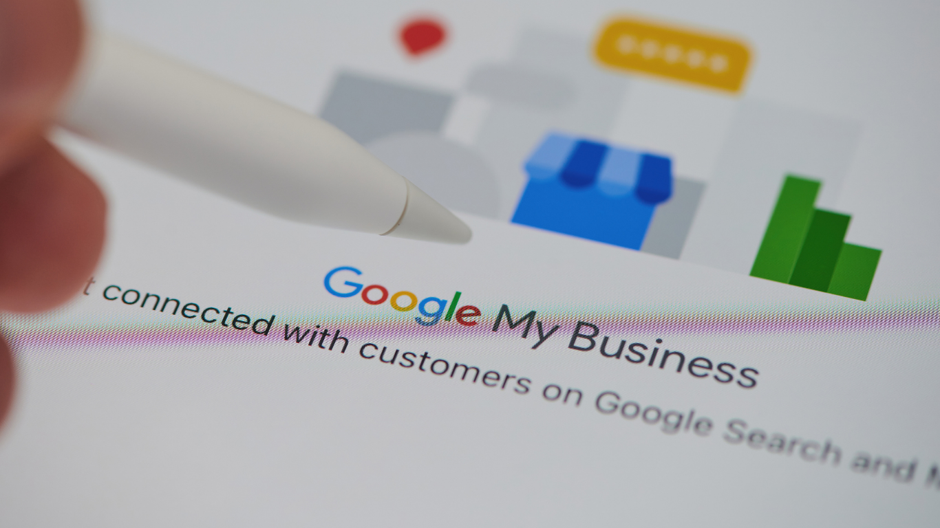 Close-up of a stylus pointing to a Google My Business listing on a screen, showing tools for boosting local SEO and online visibility.